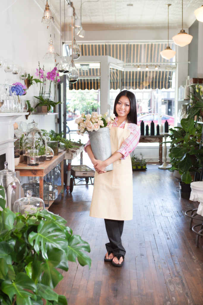 Woman holding flowers in a flower shop looking at the camera