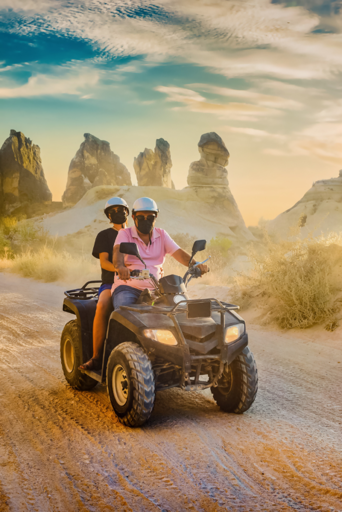 two people on an ATV 4-wheeler in the desert